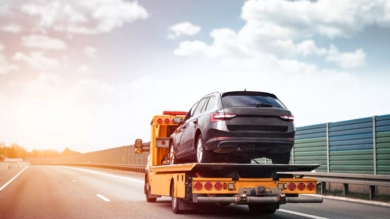 Reliable Towing and Recovery Services: 24/7 Assistance for Vehicle Breakdowns and Accidents. Emergency roadside assistance on the highway. side view of the flatbed tow truck with a damaged vehicle